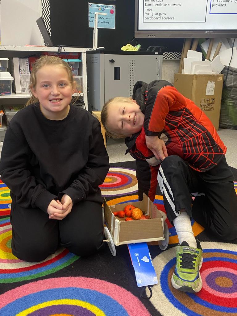 boy and girl with finished wagon with pumpkins