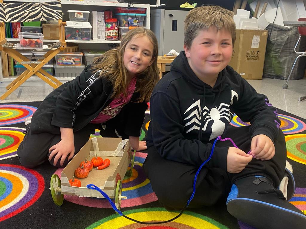 boy and girl with finished wagon with pumpkins