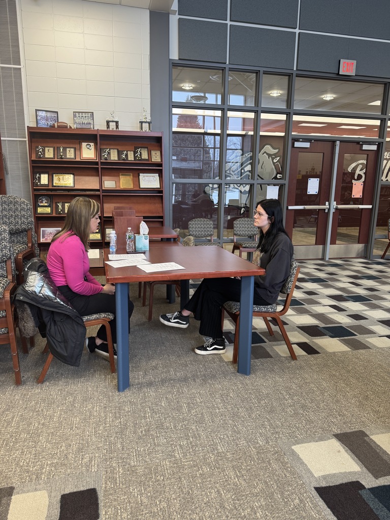 student being interview by an adult in the library