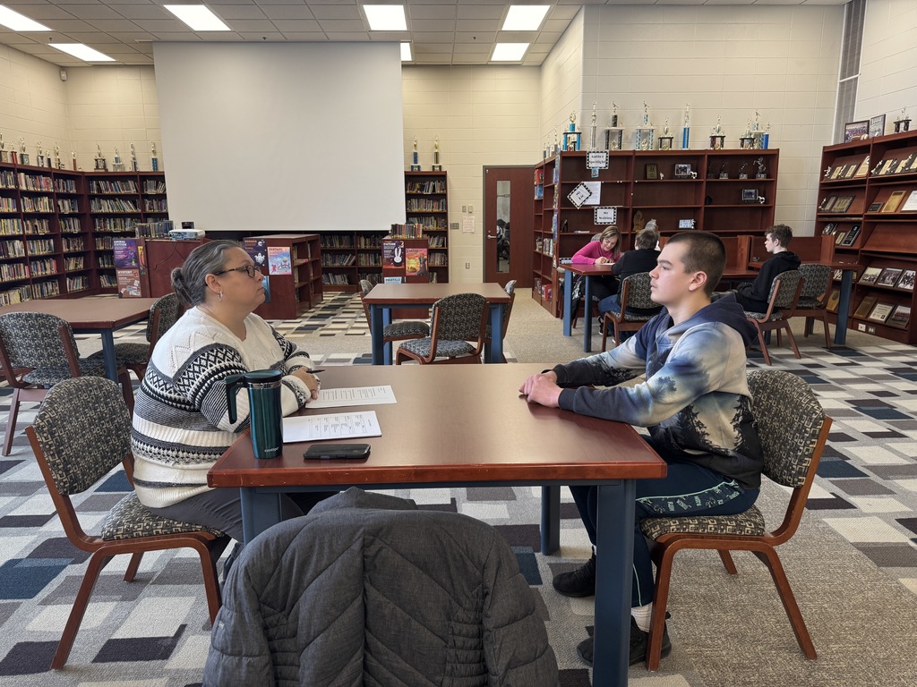 student being interview by an adult in the library