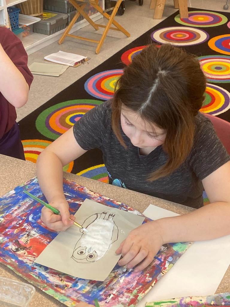 students holding their painted owl project