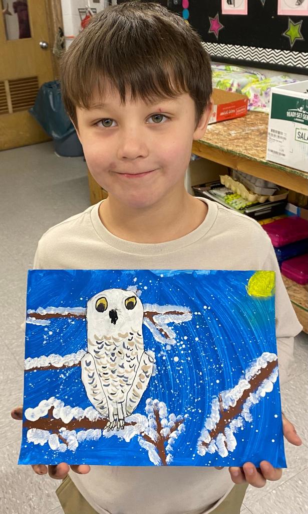 students holding their painted owl project