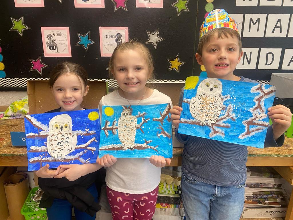 students holding their painted owl project