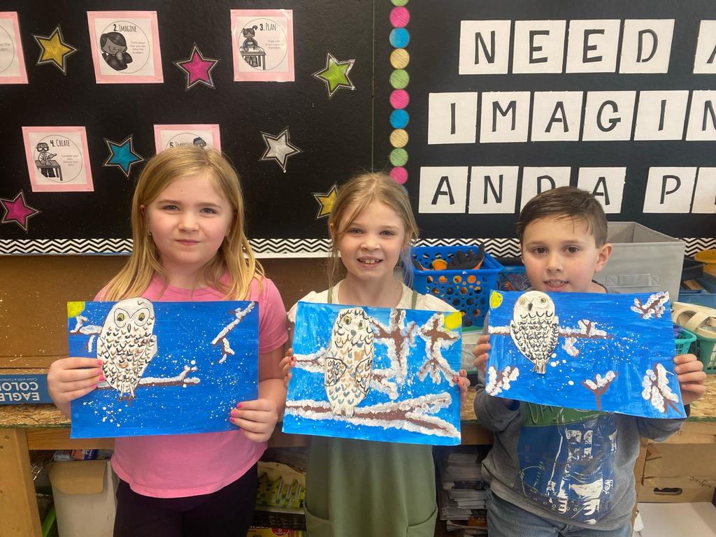students holding their painted owl project