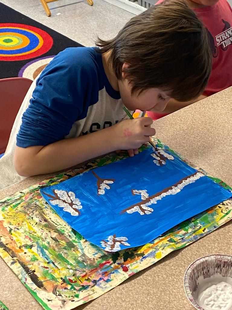 students holding their painted owl project