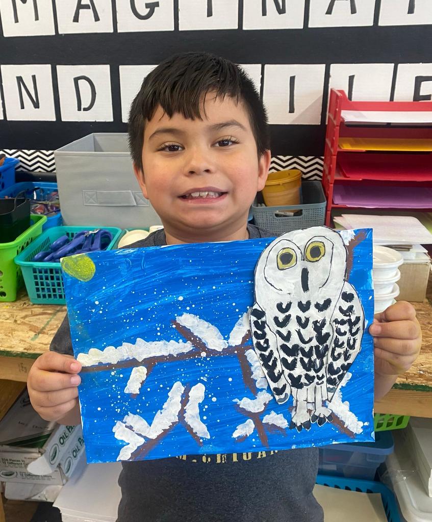 students holding their painted owl project