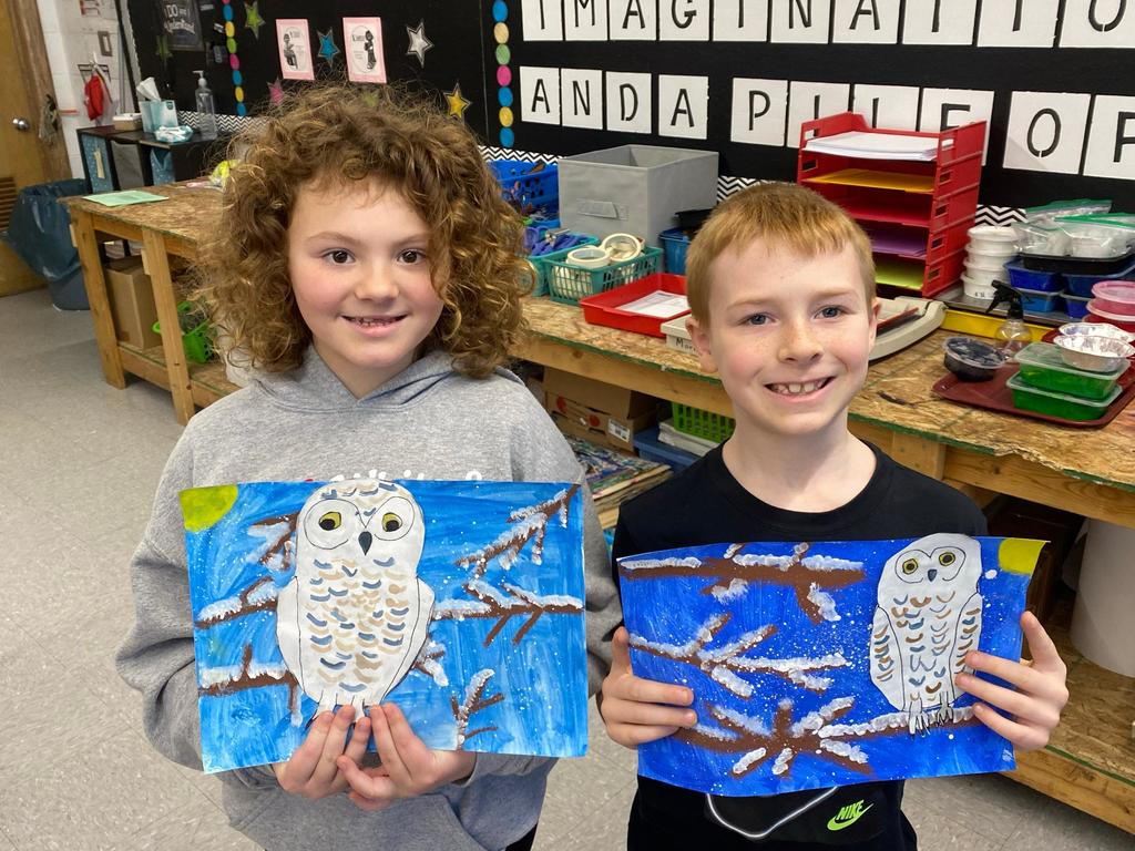 students holding their painted owl project