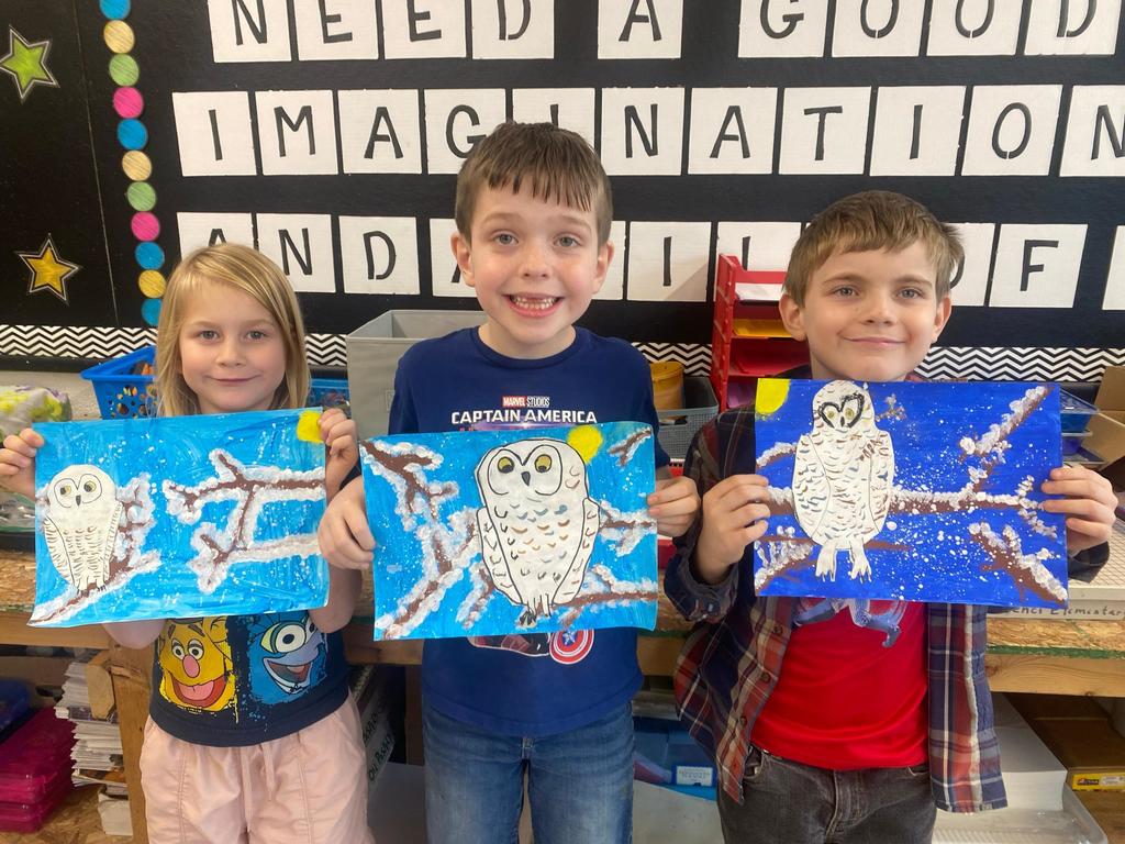 students holding their painted owl project