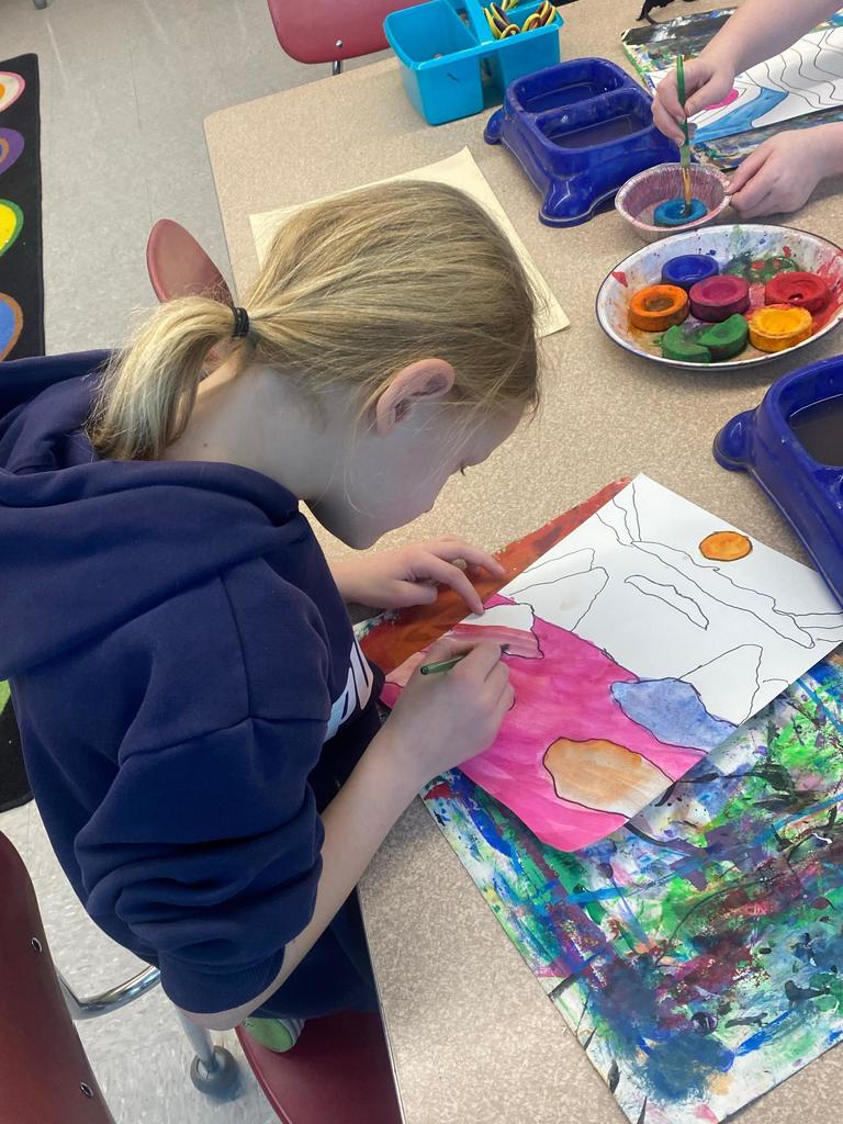 student holding abstract art project