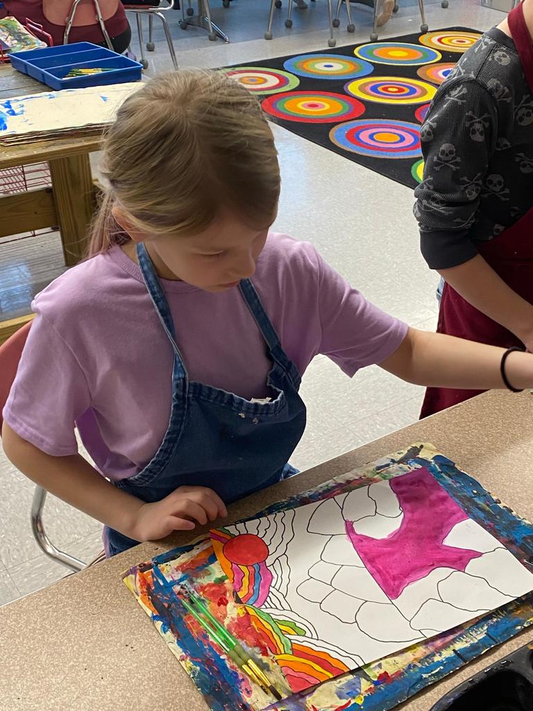 student holding abstract art project