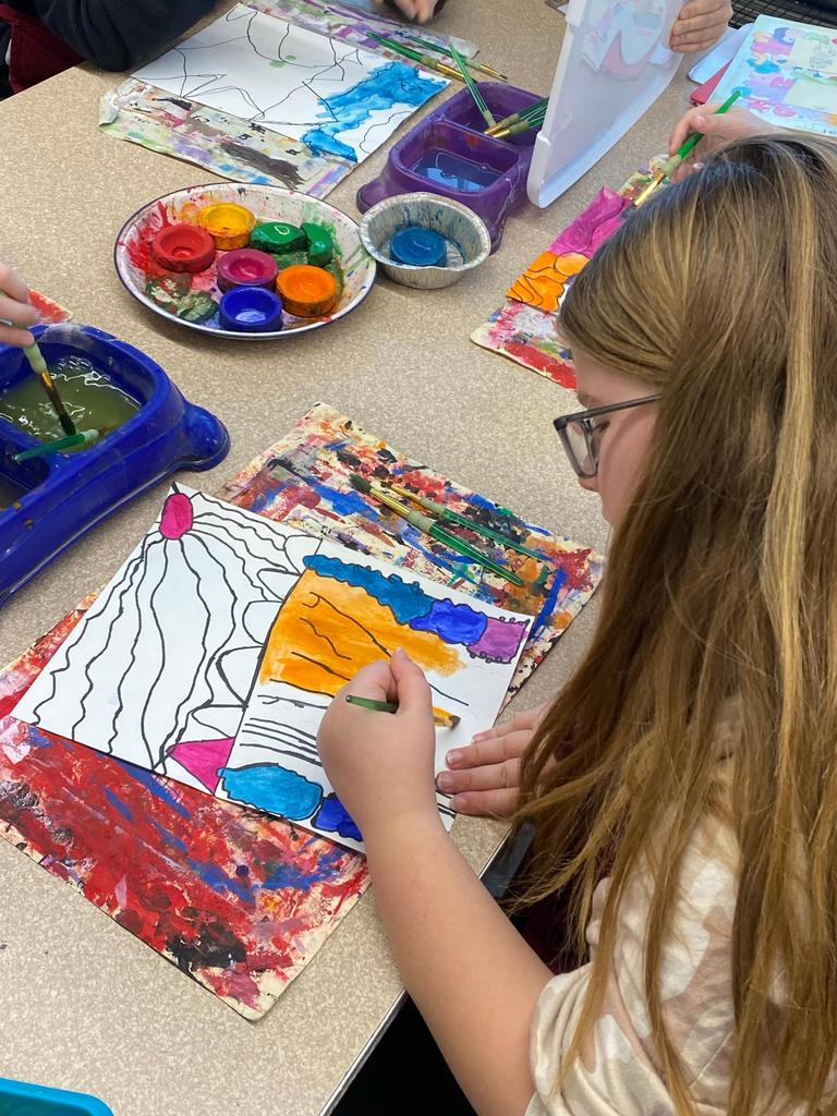 student holding abstract art project