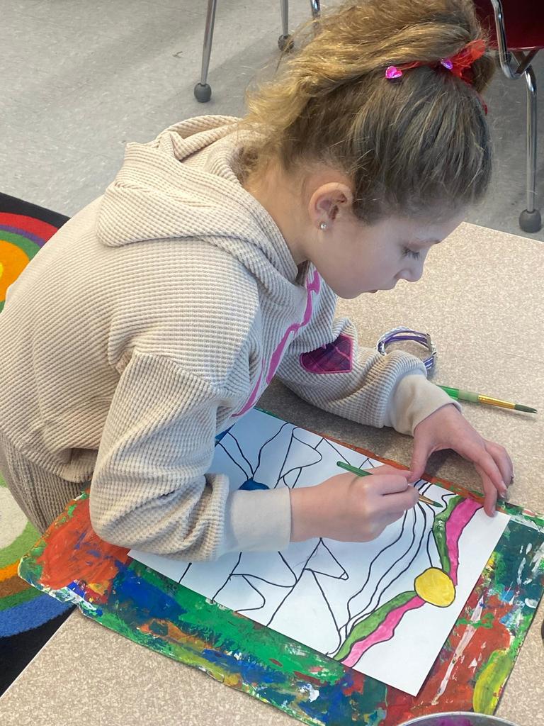 student holding abstract art project