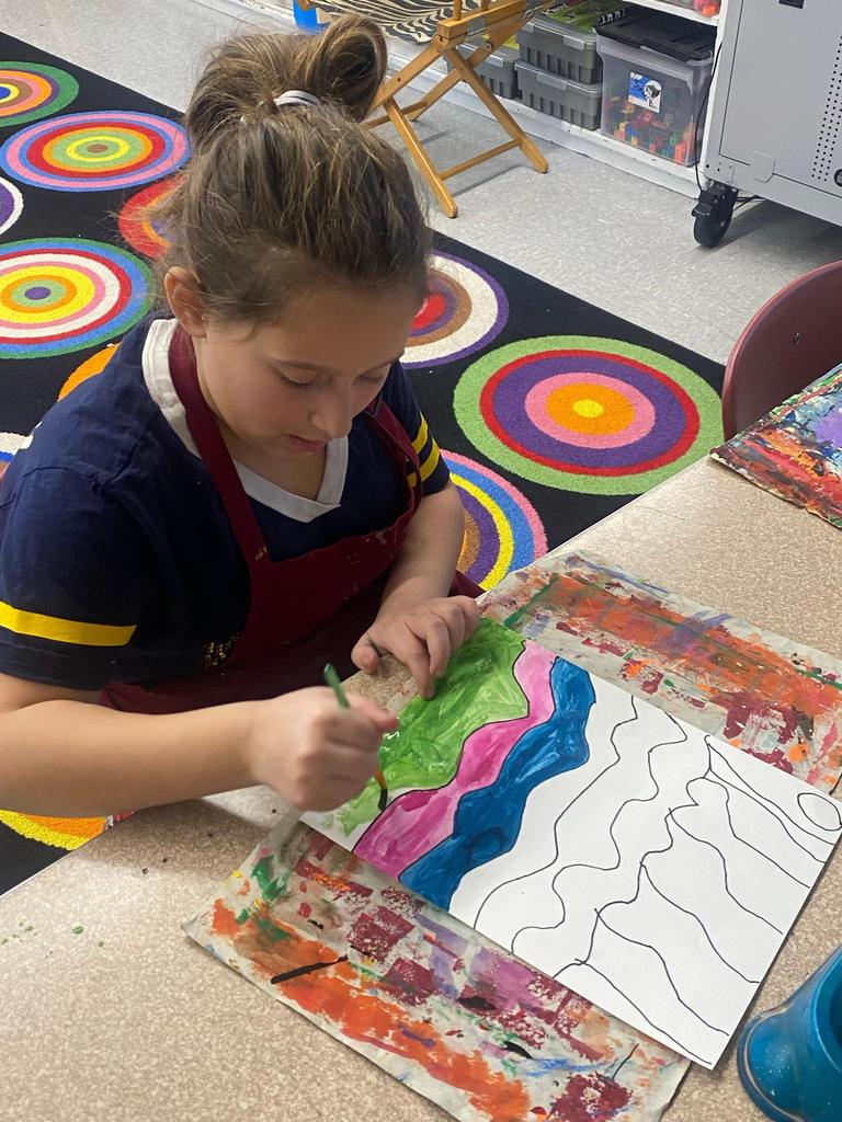 student holding abstract art project