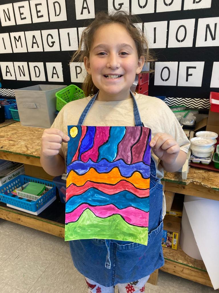 student holding abstract art project