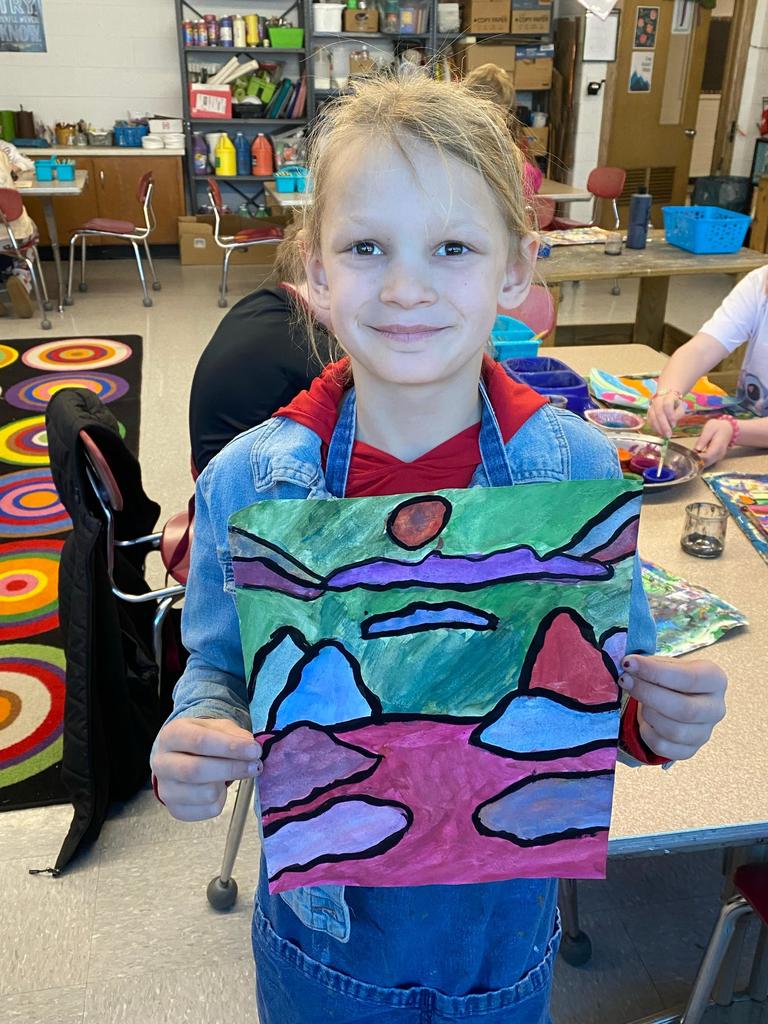 student holding abstract art project