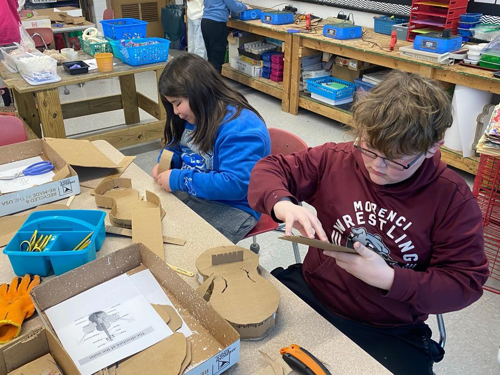 students making violins out of cardboard