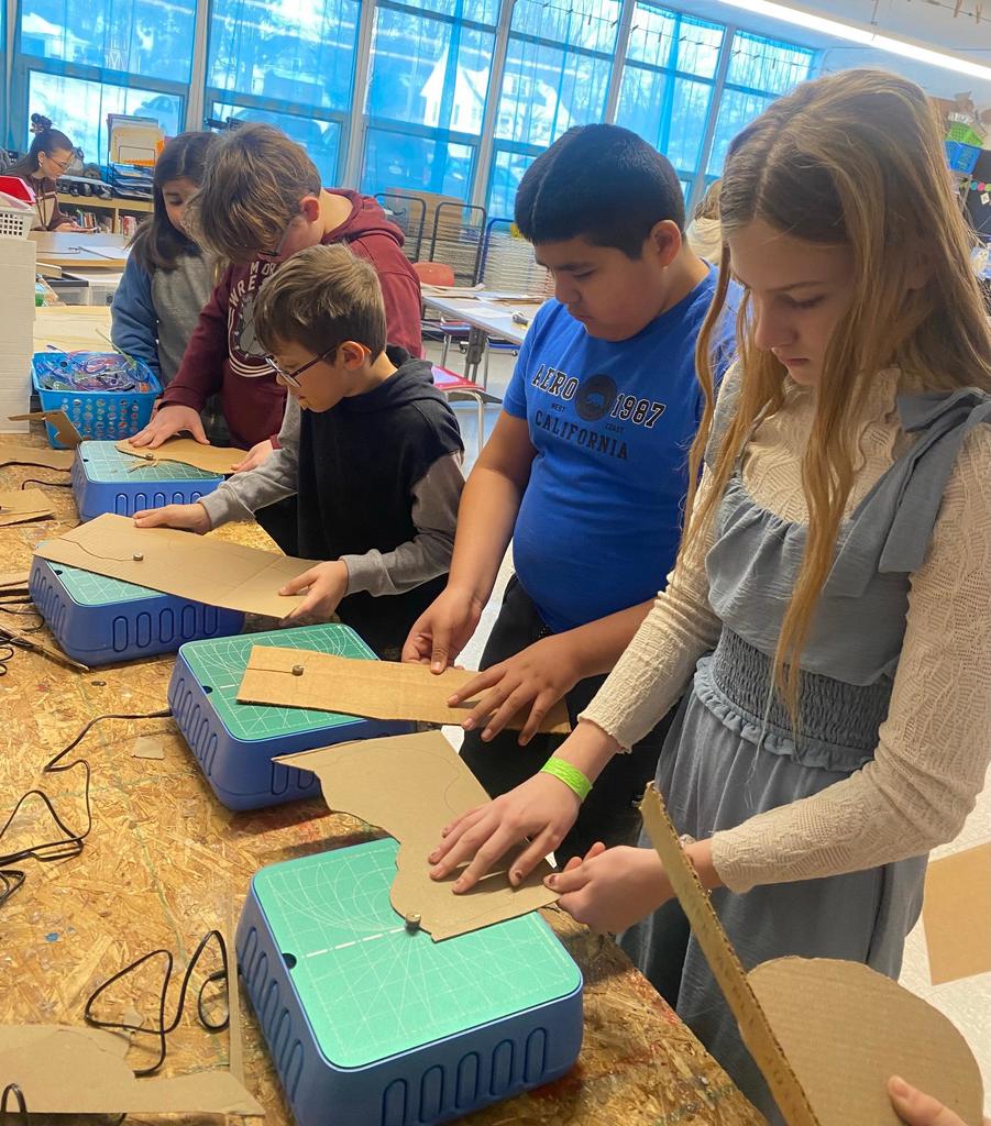 students making violins out of cardboard