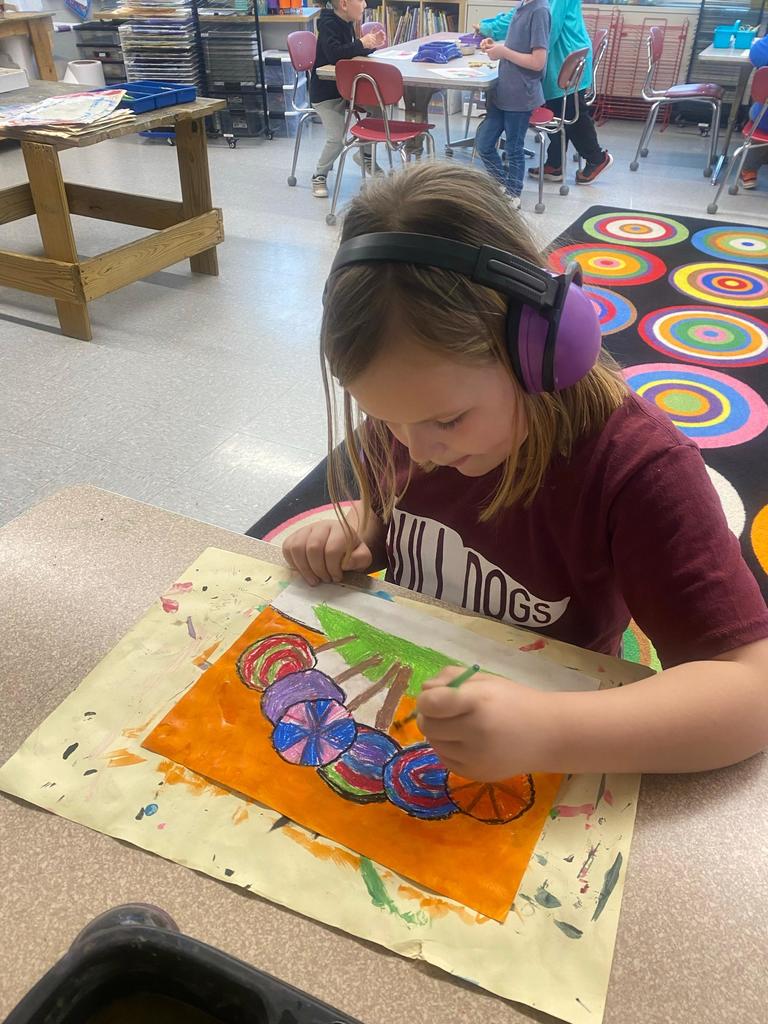 student painting a lollipop picture