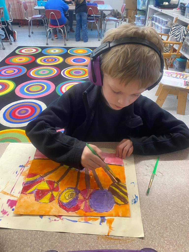 student painting a lollipop picture