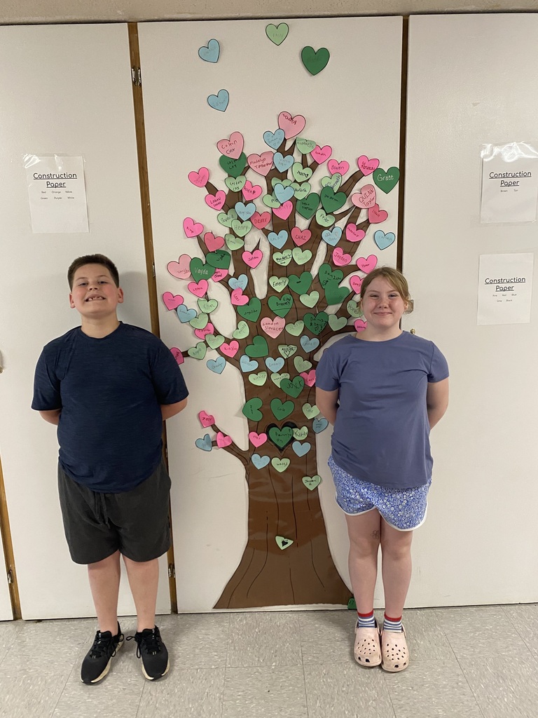 two students standing in front of the kindness tree