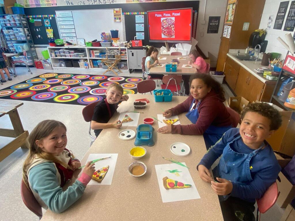 group of student wroking on their pizza art work.