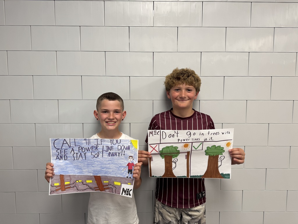 Two students holding posters they drew for a poster contest.