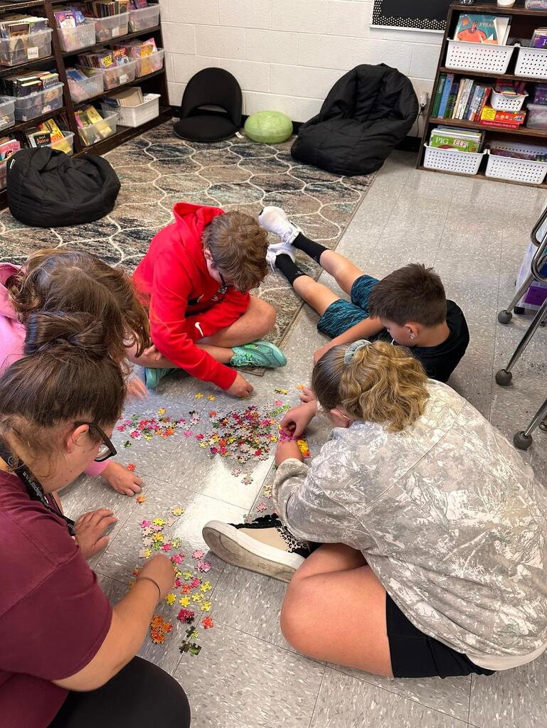 a group of students working on a puzzle