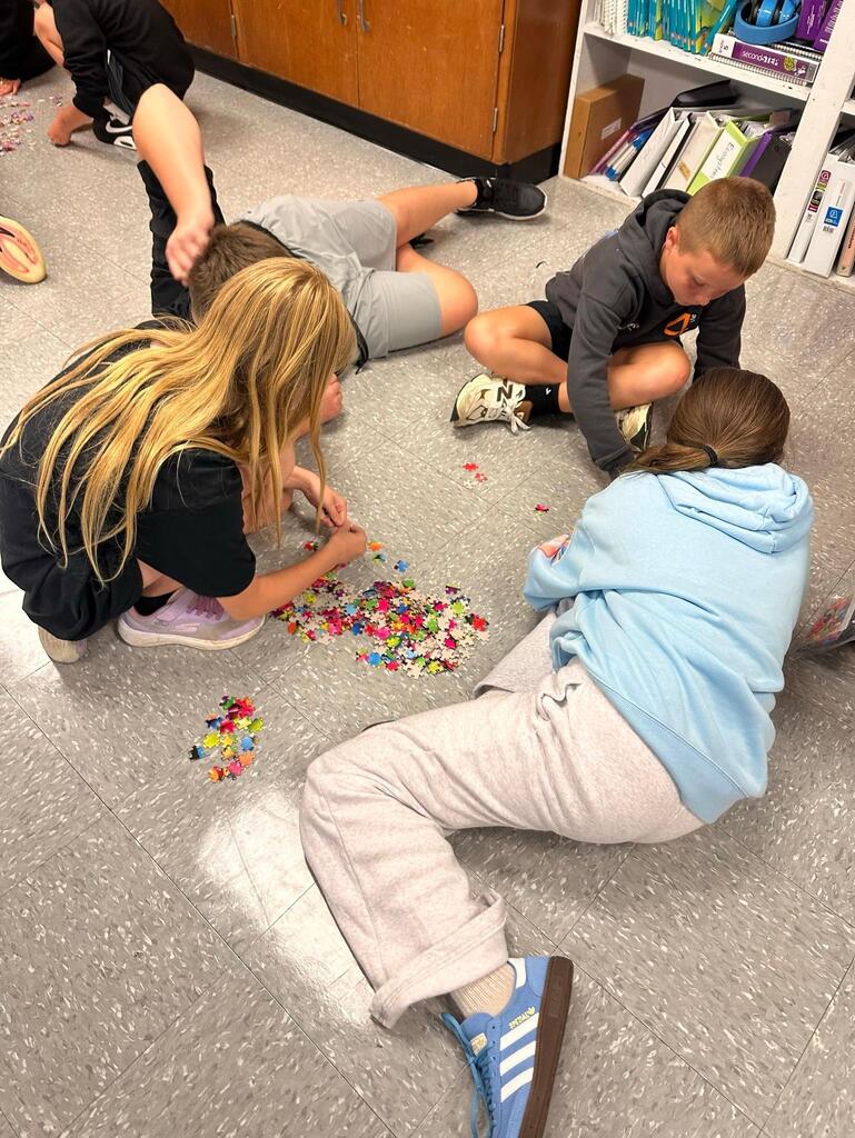 a group of students working on a puzzle