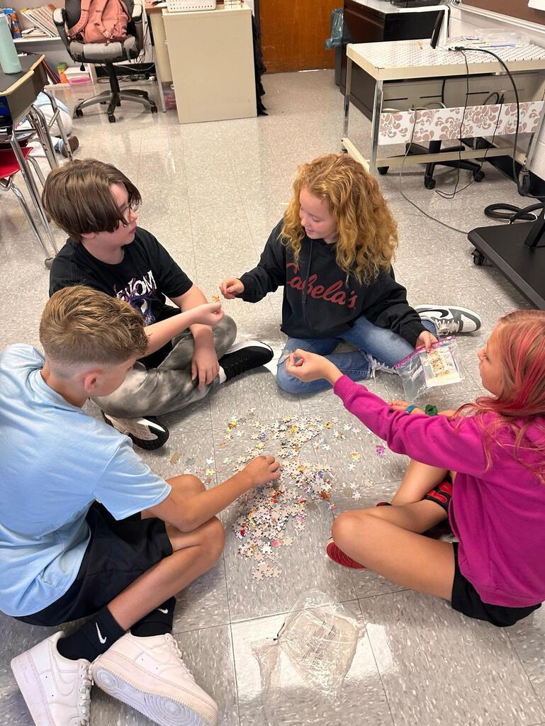 a group of students working on a puzzle