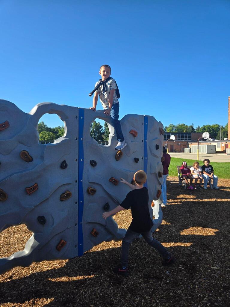 students playing on the rock climbing wall