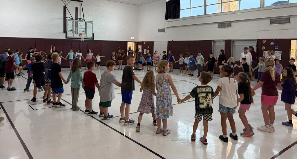 students holding hands in the bym
