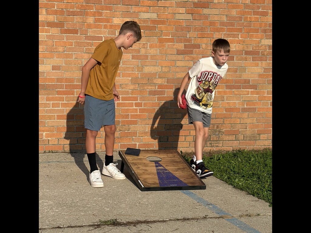 two students playing cornhole
