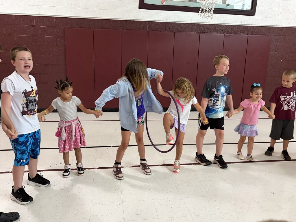 students holding hands and having a hula hoop passing