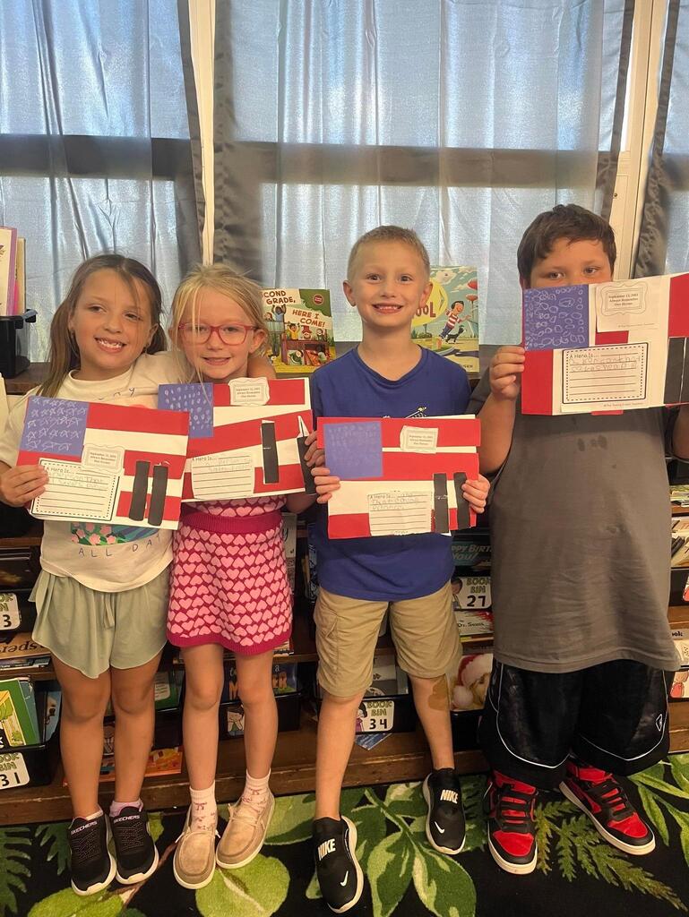 four students holding a flag project