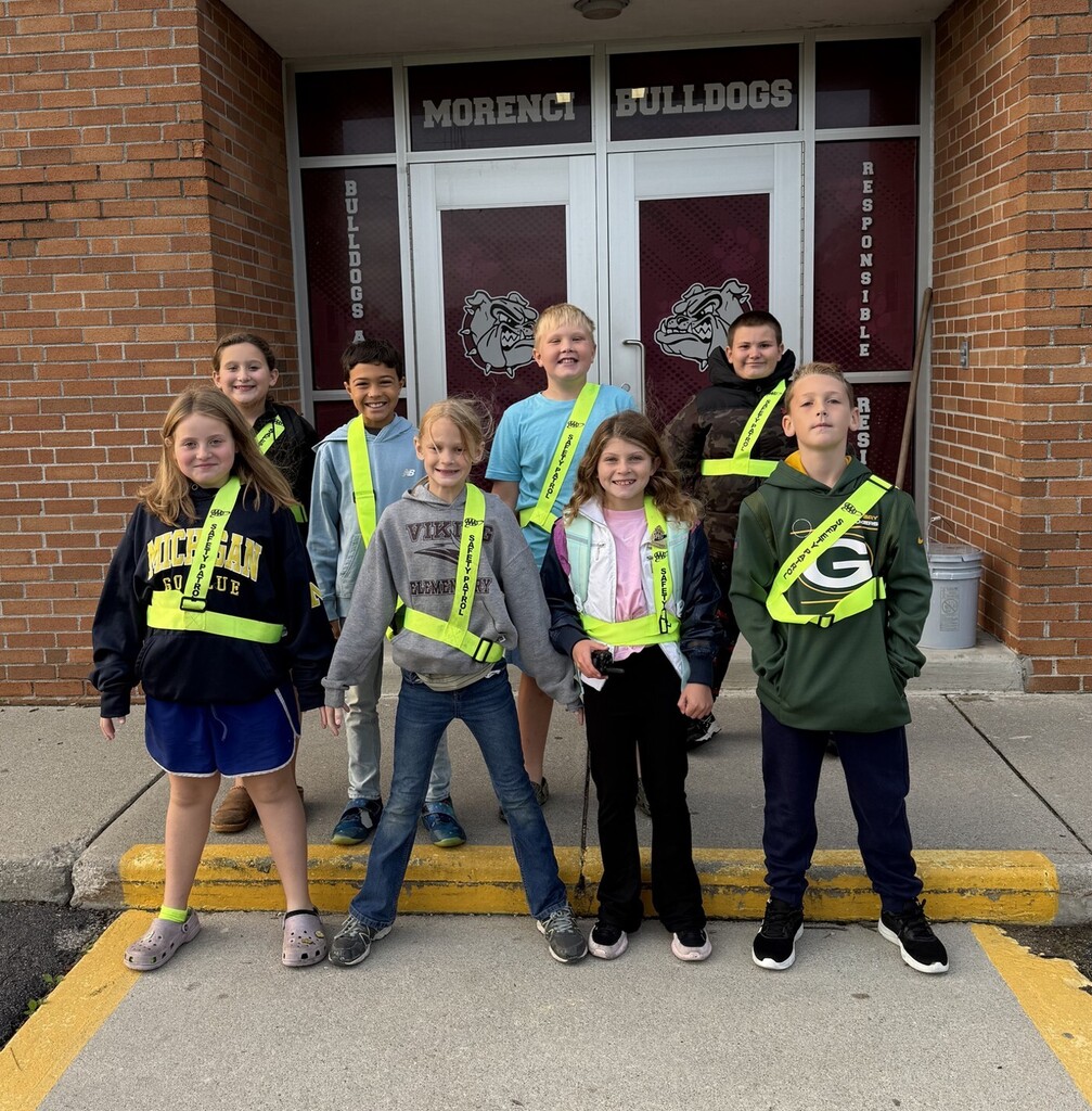 eight student standing with their safety patrol badges on.