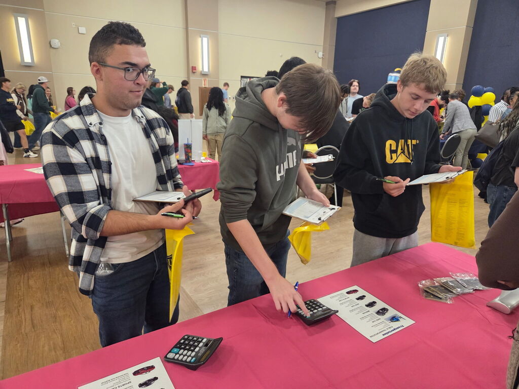 three students at a booth
