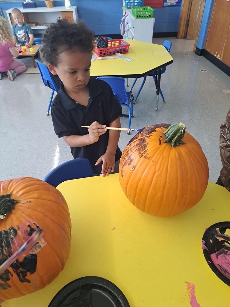 student painting pumpkin
