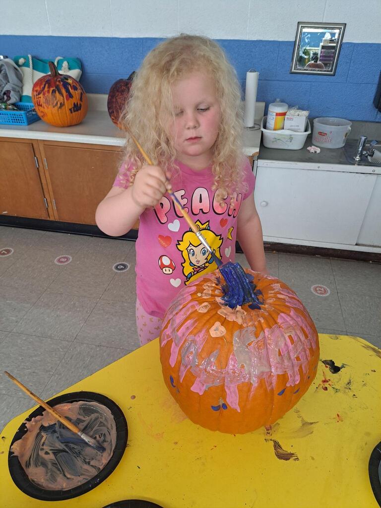 student painting their pumpkin