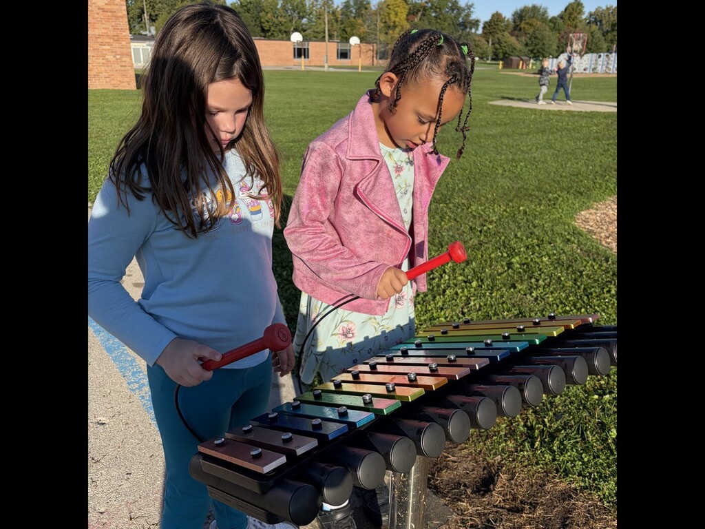 two students playing a musical instrument