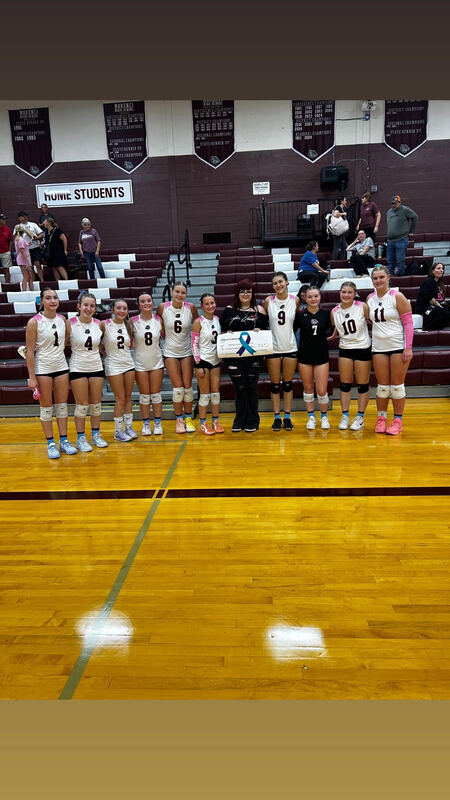 group of students holding a donation check