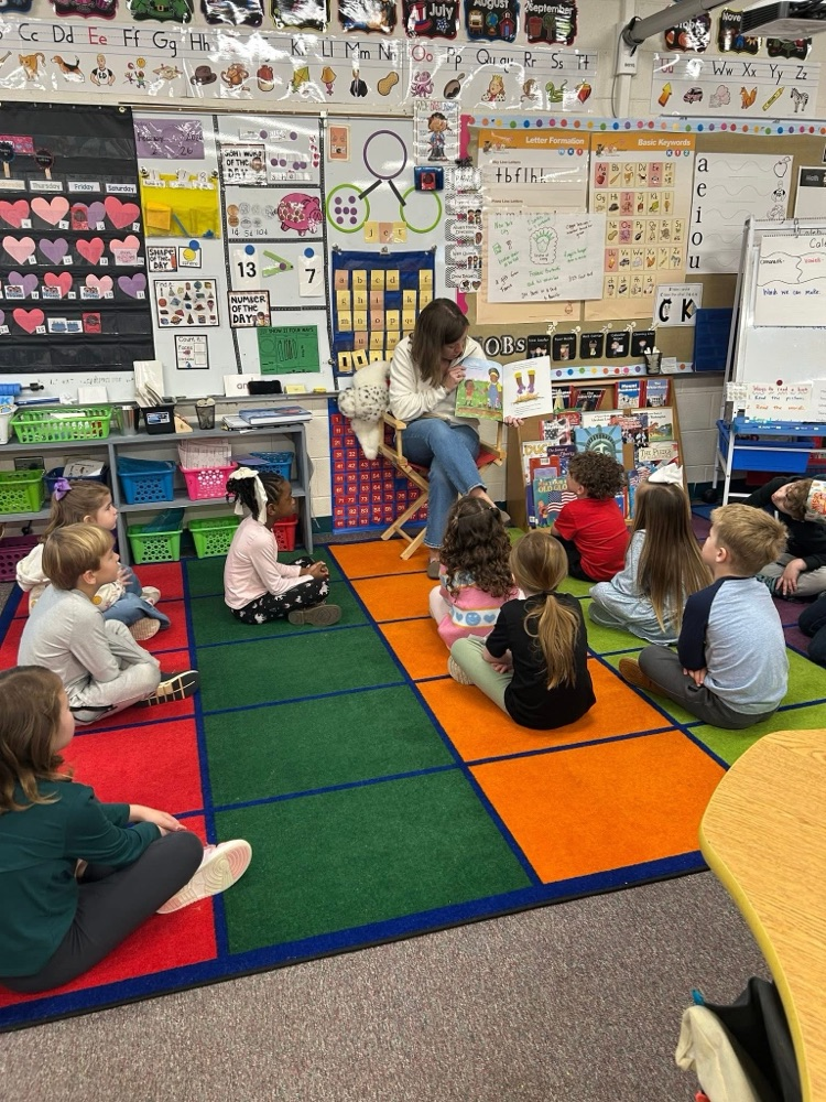 volunteer readers reading a book to students