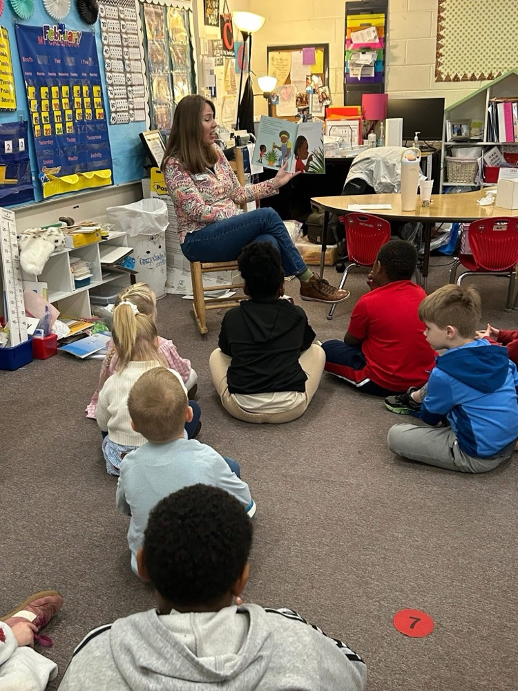 volunteer readers reading a book to students