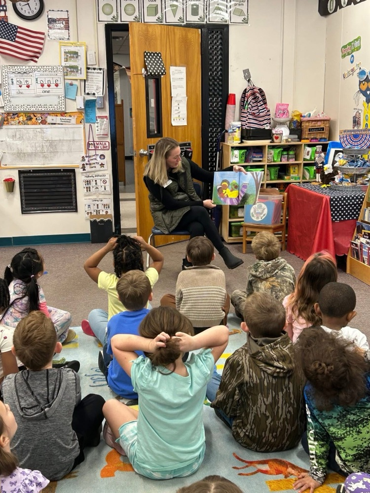 volunteer readers reading a book to students