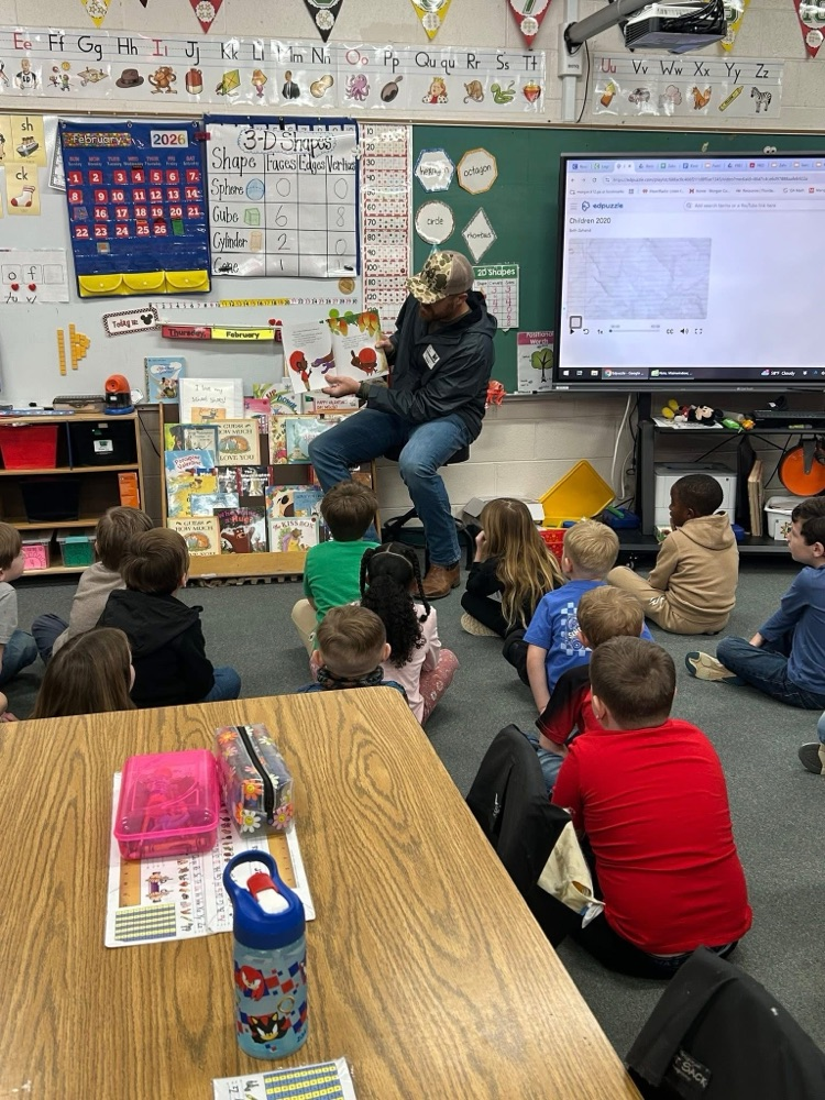 volunteer readers reading a book to students