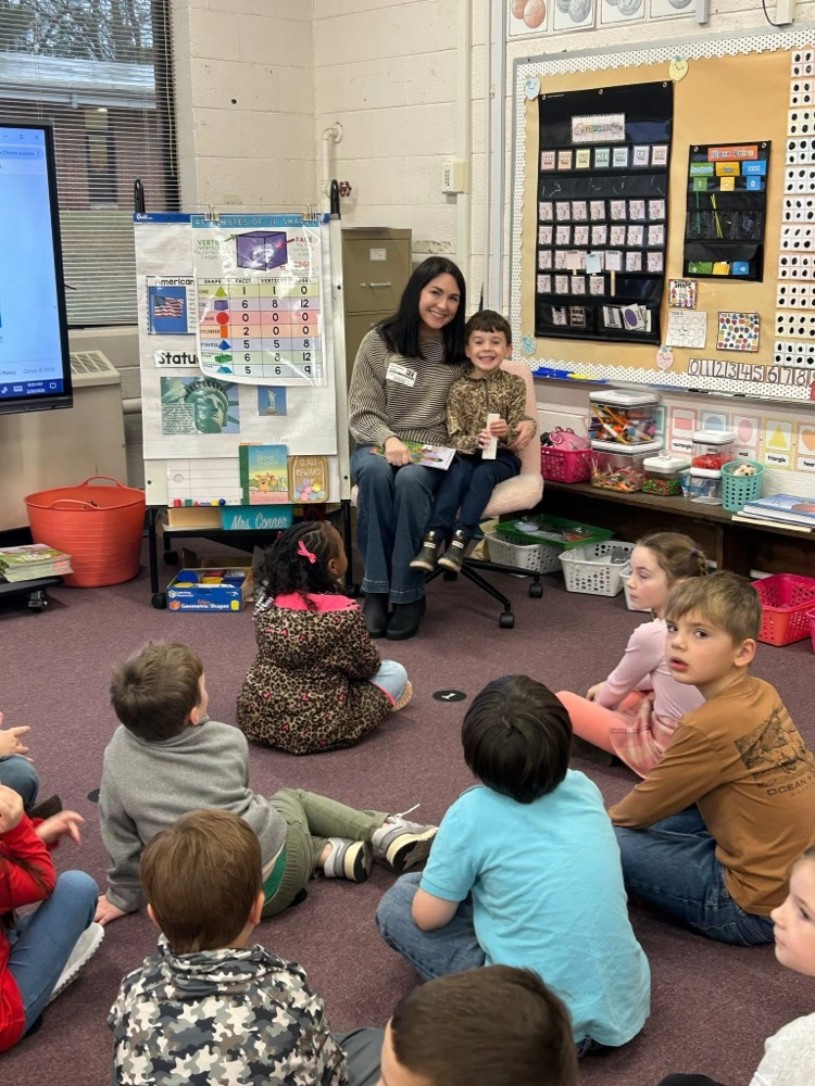 volunteer readers reading a book to students