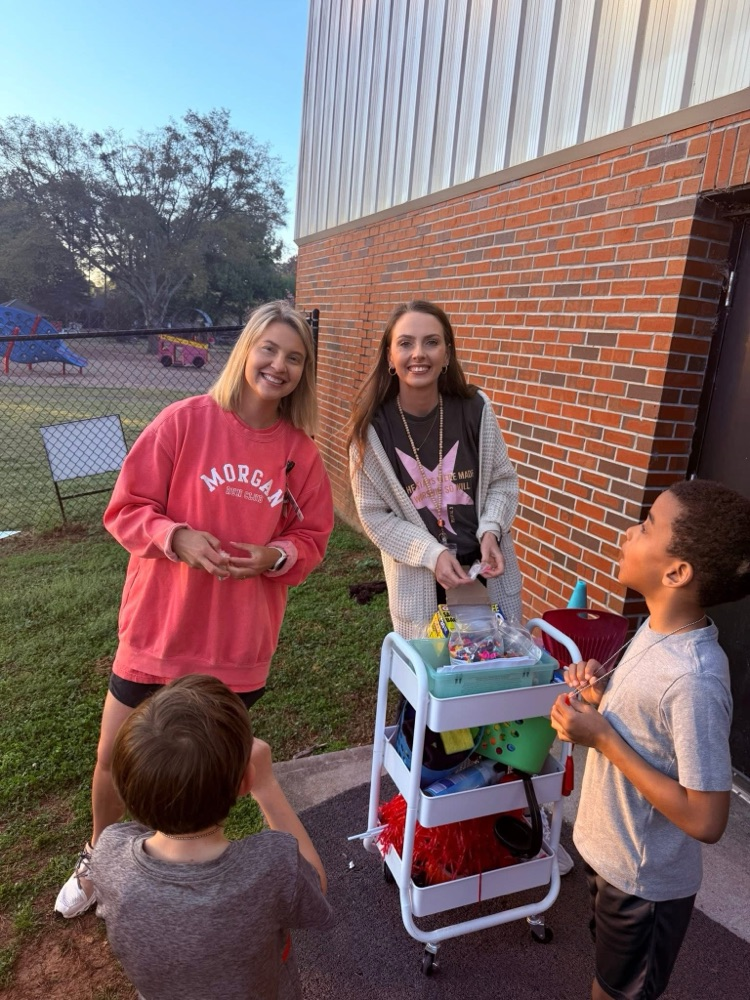 Coach Redd and Mrs. Thrift check the students in before they begin running for Track Club.