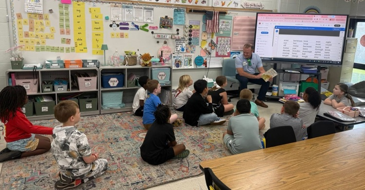 volunteers from the Mayor’s Reading club read aloud to students. 
