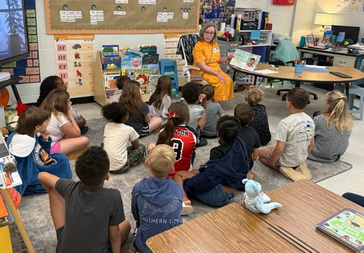 volunteers from the Mayor’s Reading club read aloud to students. 