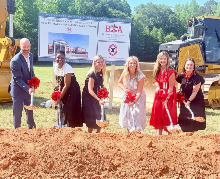 MCPS administrative team and the principal for MCES next year pose with shovels at the groundbreaking ceremony   
