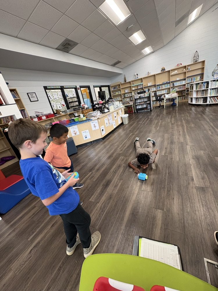 Students used a remote to code a new robot in the library. 